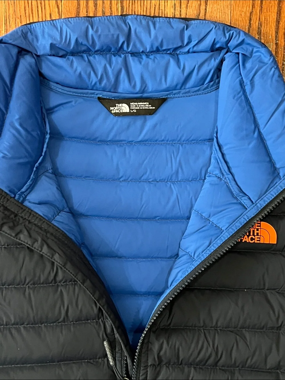 The North Face Black Quilted Down Vest with Blue Lining and Orange Logo